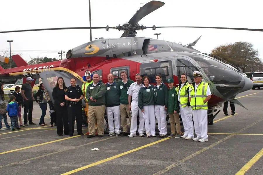 VBVRS members and community partners pose with a Sentara medical helicopter at a community event