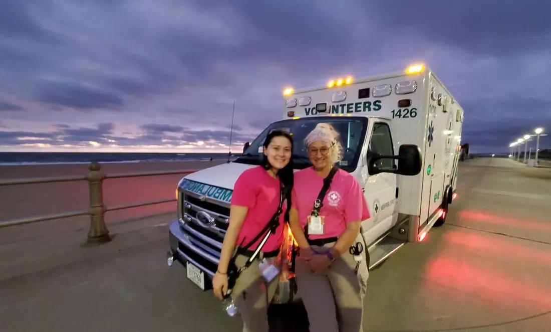 Two VBVRS volunteers by a rescue vehicle at sunrise on the beach