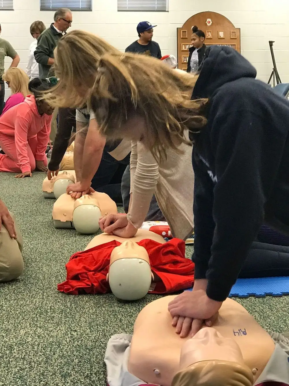 People practicing CPR on manikins at a free VBVRS training class